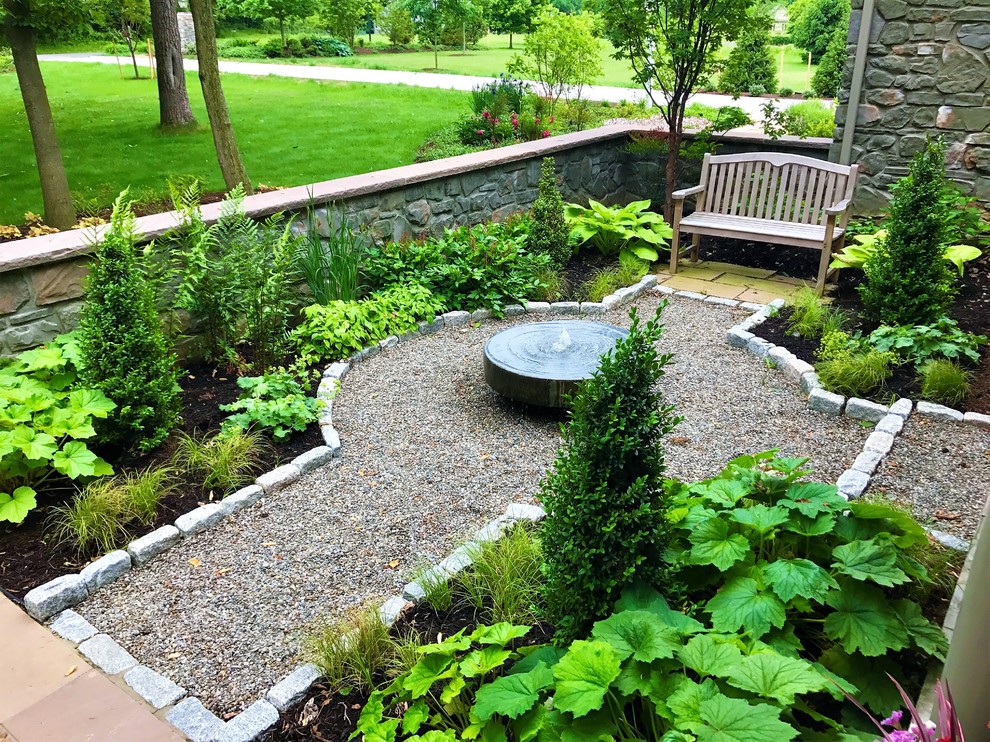 Idée de décoration pour un grand jardin avant tradition avec des pavés en pierre naturelle.