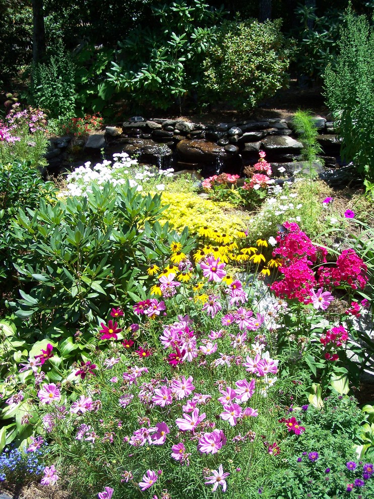 На фото: солнечный, летний сад с прудом на переднем дворе в стиле модернизм с хорошей освещенностью и покрытием из каменной брусчатки
