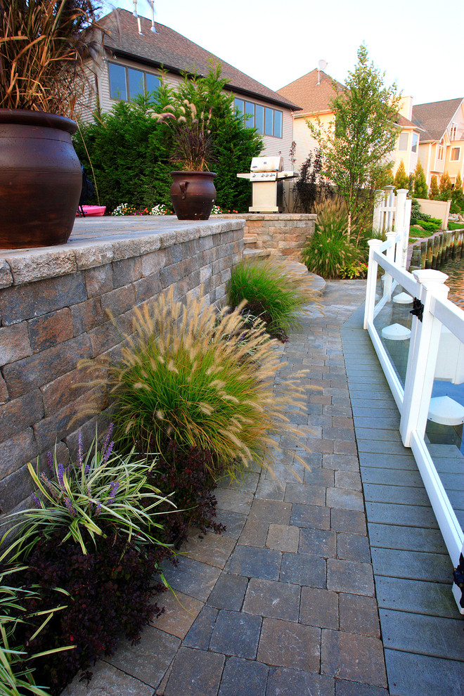 Medium sized traditional back garden in New York with a water feature and brick paving.