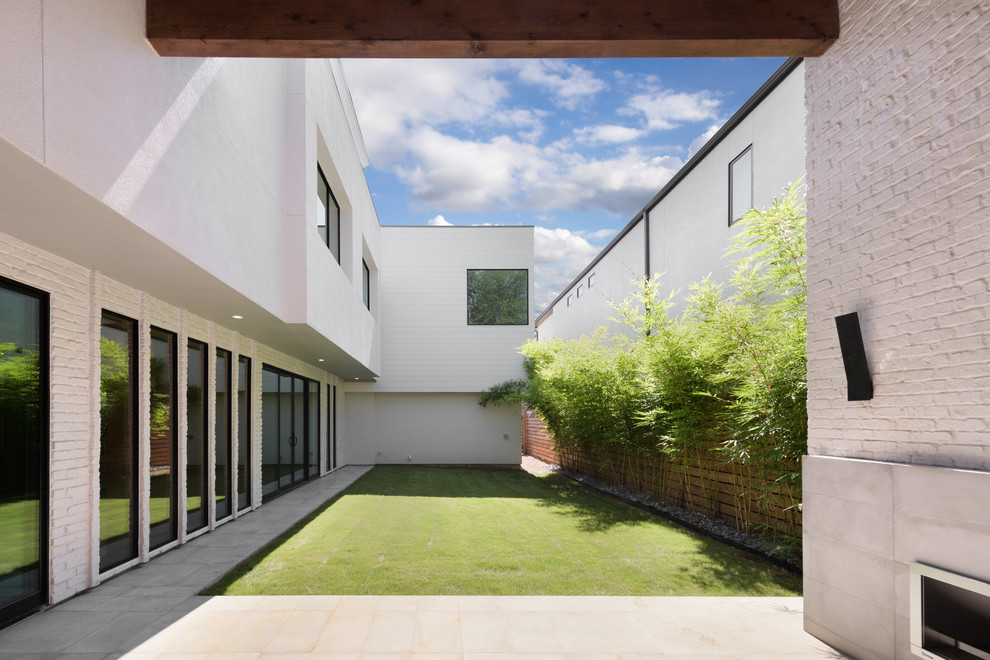 Foto di un giardino minimal esposto a mezz'ombra dietro casa con pavimentazioni in cemento e un caminetto