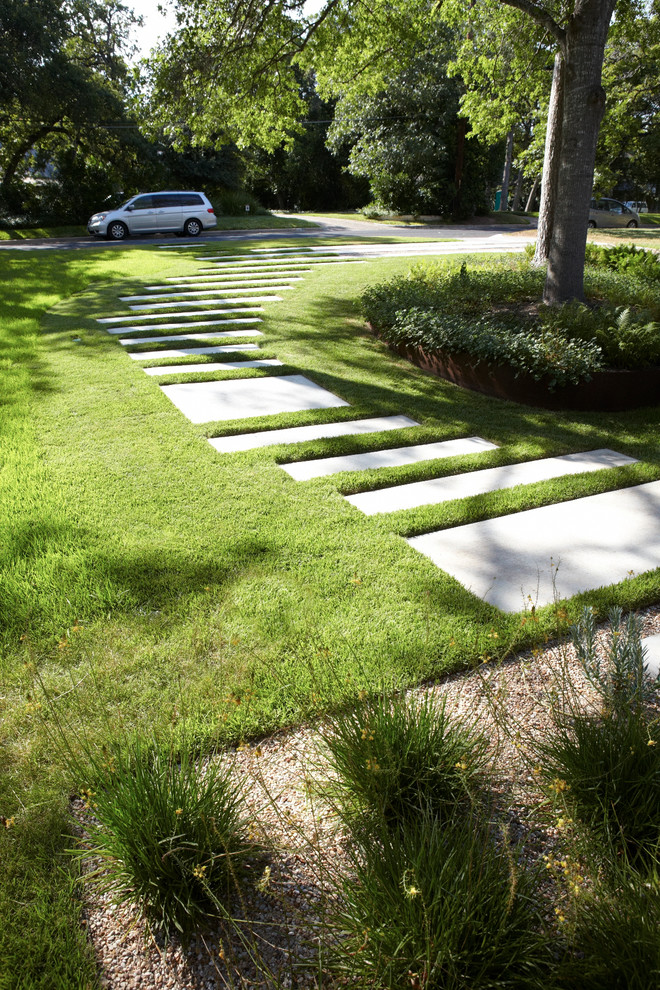 Inspiration för en mellanstor 60 tals uppfart i delvis sol framför huset, med en trädgårdsgång och marksten i betong