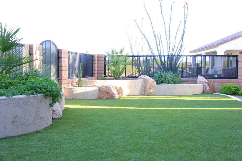 Ejemplo de jardín de secano mediterráneo de tamaño medio en verano en patio trasero con muro de contención, exposición parcial al sol y gravilla