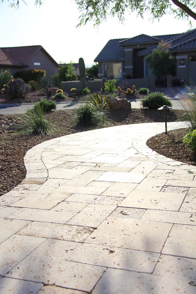 Photo of a medium sized mediterranean front xeriscape full sun garden for summer in Phoenix with natural stone paving.