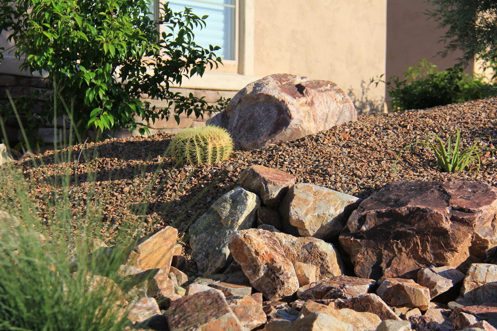 Inspiration for a mid-sized mediterranean drought-tolerant and full sun front yard gravel landscaping in Phoenix for summer.