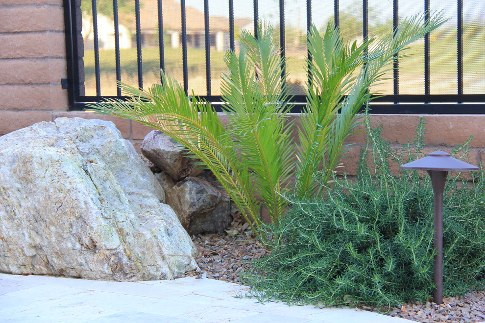 Design ideas for a mid-sized mediterranean drought-tolerant and partial sun backyard gravel retaining wall landscape in Phoenix for summer.