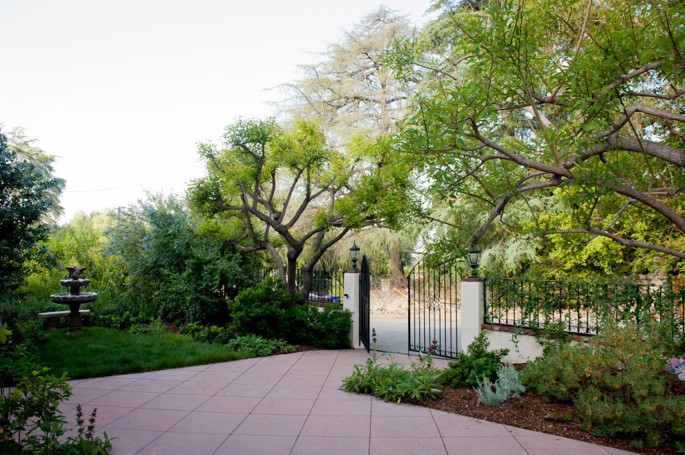 Свежая идея для дизайна: большой весенний засухоустойчивый сад на переднем дворе в средиземноморском стиле с воротами, полуденной тенью и мощением тротуарной плиткой - отличное фото интерьера