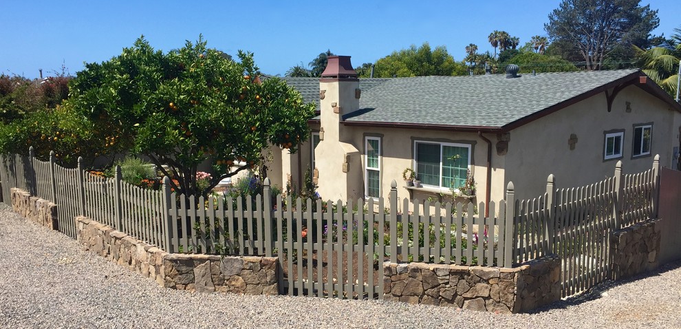 This is an example of a medium sized rural front formal full sun garden for spring in San Diego with a retaining wall and natural stone paving.