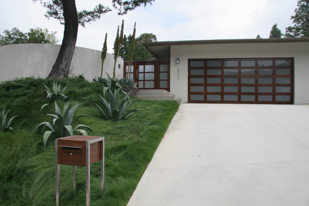 Medium sized contemporary front driveway full sun garden in Los Angeles with concrete paving.