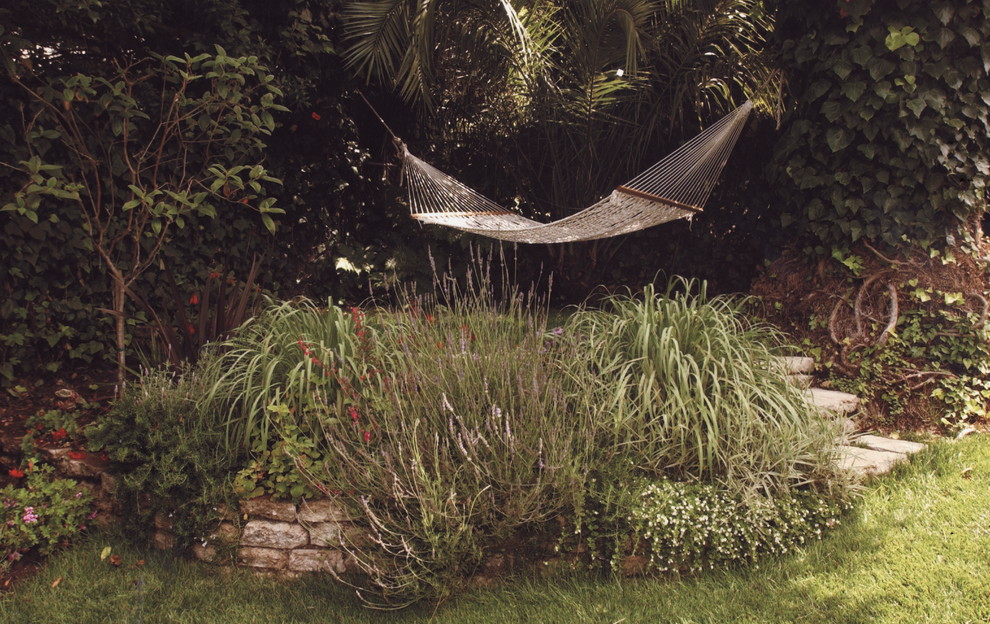 Cette image montre un jardin arrière traditionnel de taille moyenne avec une exposition partiellement ombragée et un paillis.
