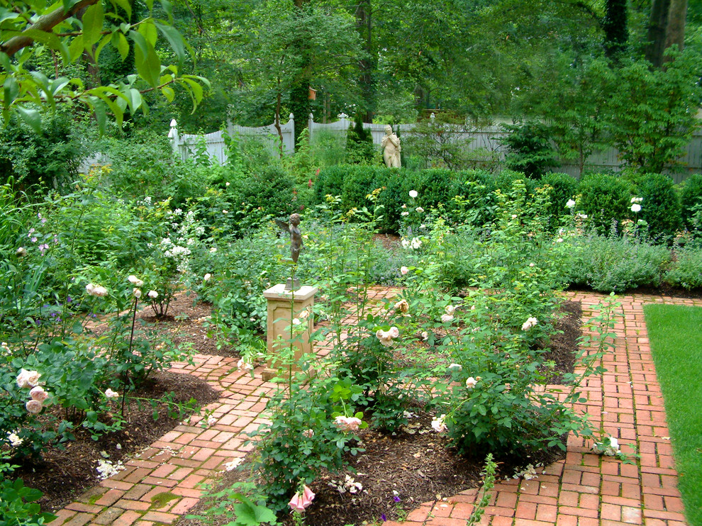 Modelo de jardín tradicional pequeño en patio trasero con adoquines de ladrillo y jardín francés