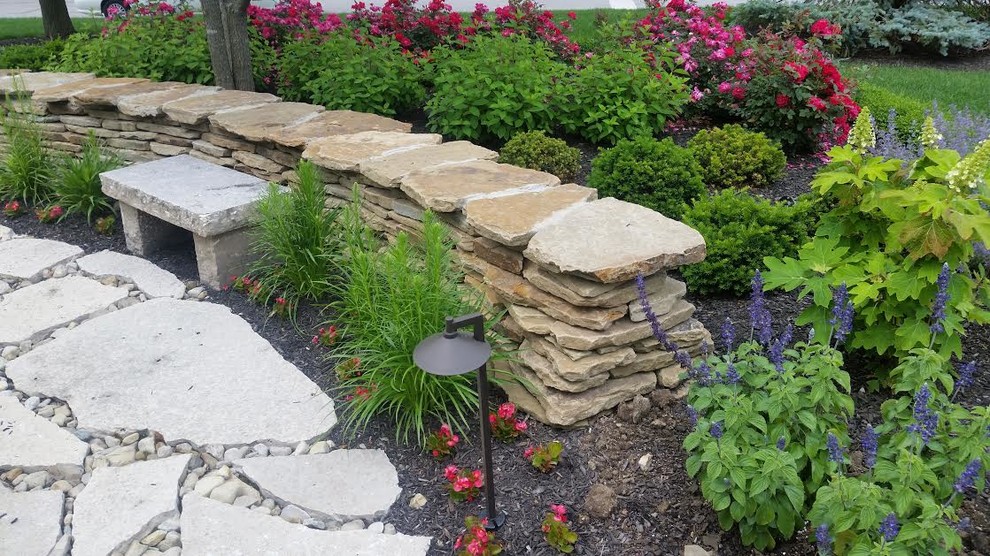 Inspiration for a large transitional full sun front yard stone landscaping in Columbus for summer.