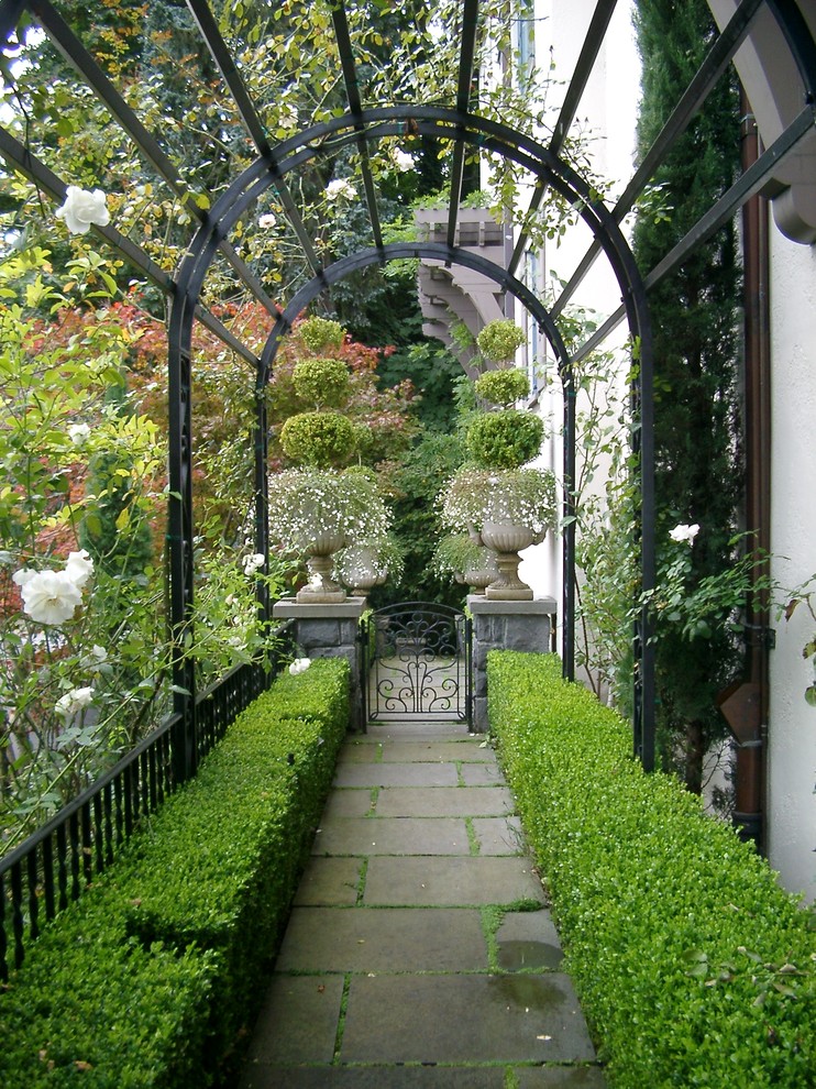 Immagine di un giardino classico esposto a mezz'ombra con un ingresso o sentiero