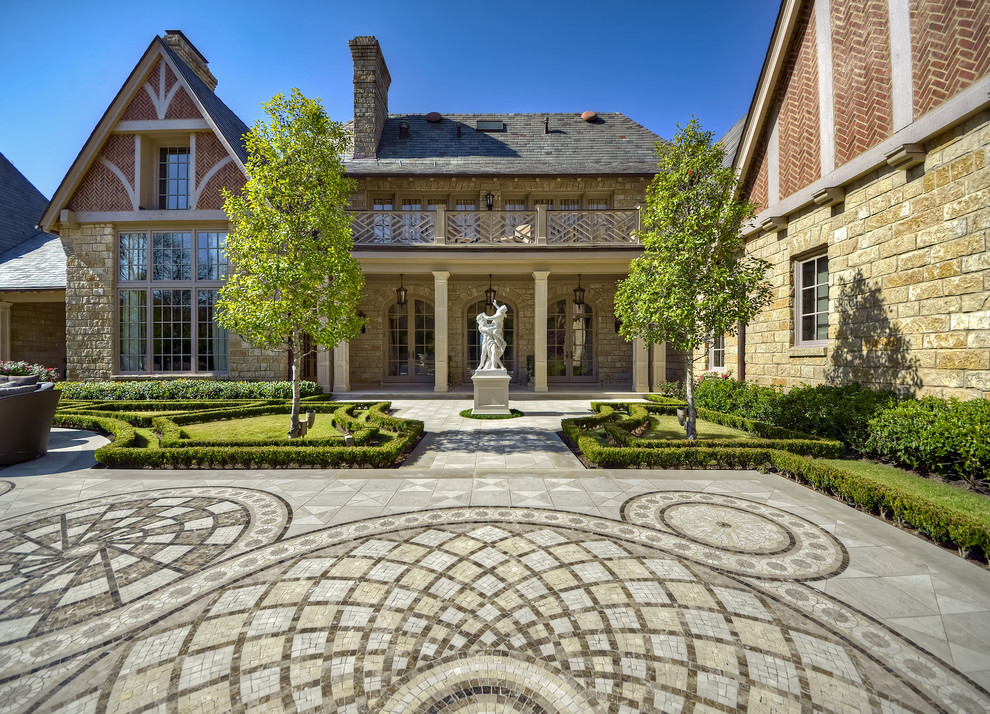 Пример оригинального дизайна: участок и сад на переднем дворе в классическом стиле с подъездной дорогой и покрытием из каменной брусчатки