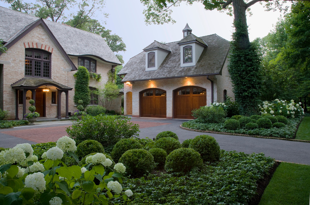 Design ideas for a large classic front driveway fully shaded garden for summer in Chicago with brick paving.