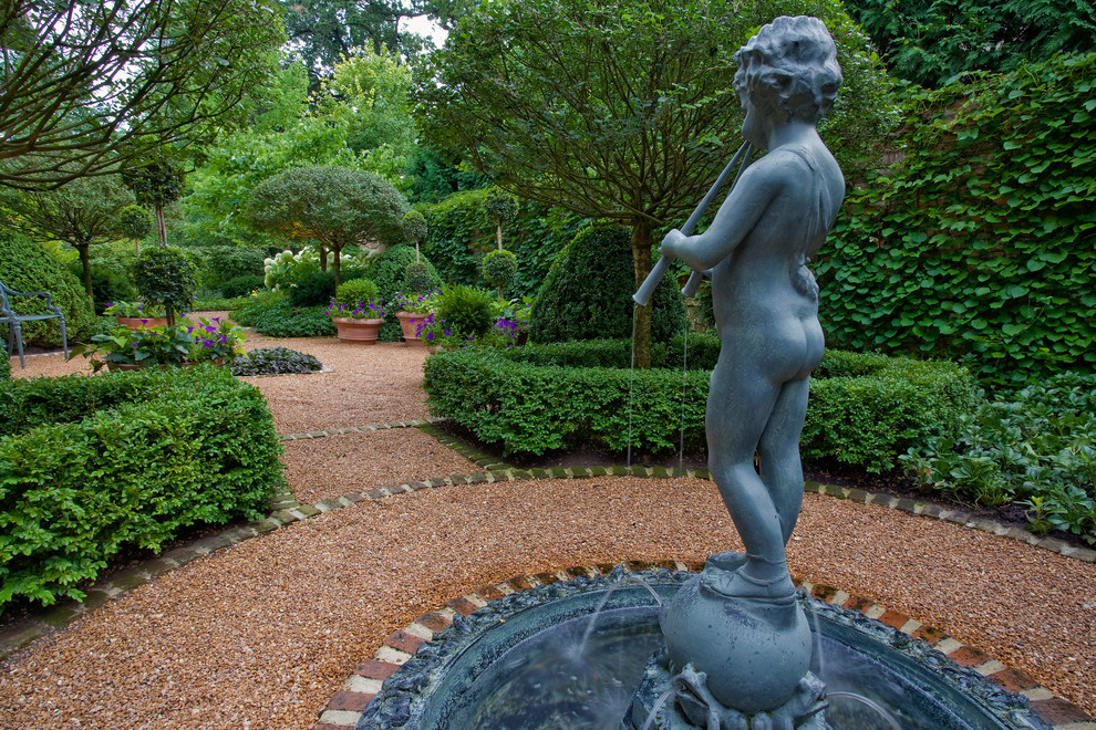 Idées déco pour un grand jardin à la française arrière classique l'été avec une exposition ombragée et du gravier.