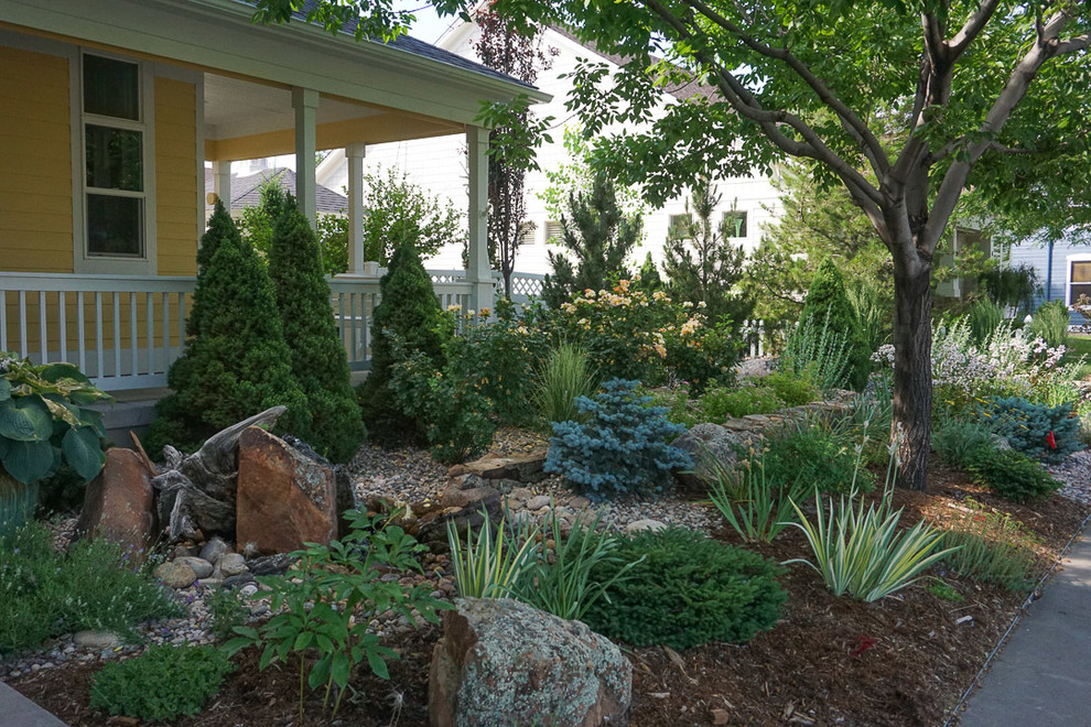 Diseño de jardín tradicional de tamaño medio en primavera en patio trasero con exposición parcial al sol y adoquines de piedra natural