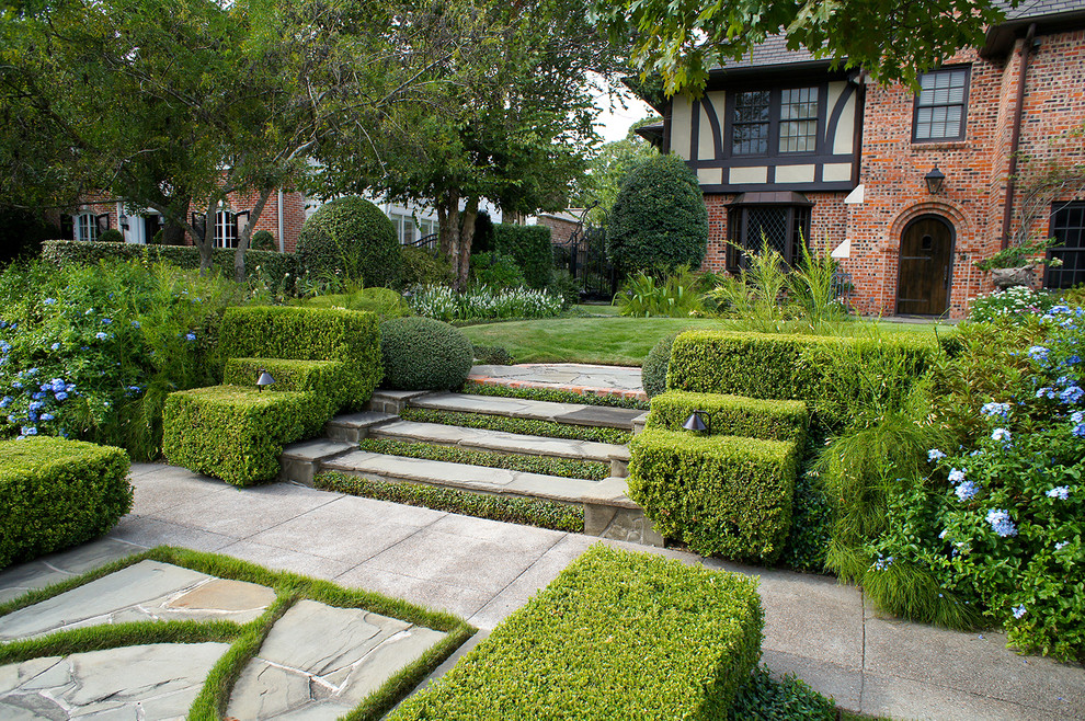 Exempel på en stor klassisk formell trädgård framför huset