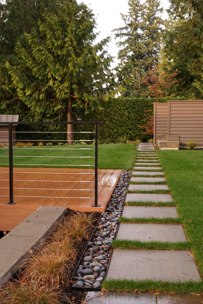 This is an example of a mid-sized modern partial sun backyard concrete paver garden path in Seattle.