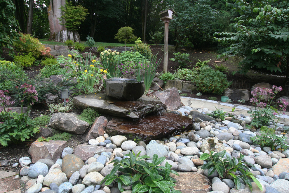 Großer Klassischer Garten hinter dem Haus mit Wasserspiel und Natursteinplatten in Seattle