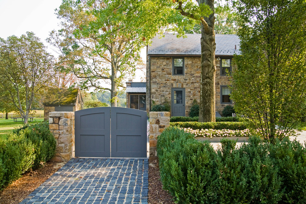 Design ideas for an expansive farmhouse driveway partial sun garden in Philadelphia with natural stone paving.