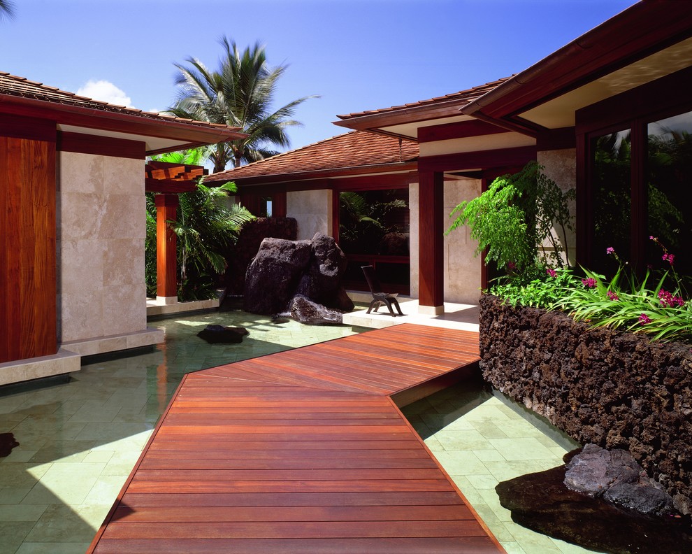 Immagine di un giardino tropicale davanti casa con fontane e pedane