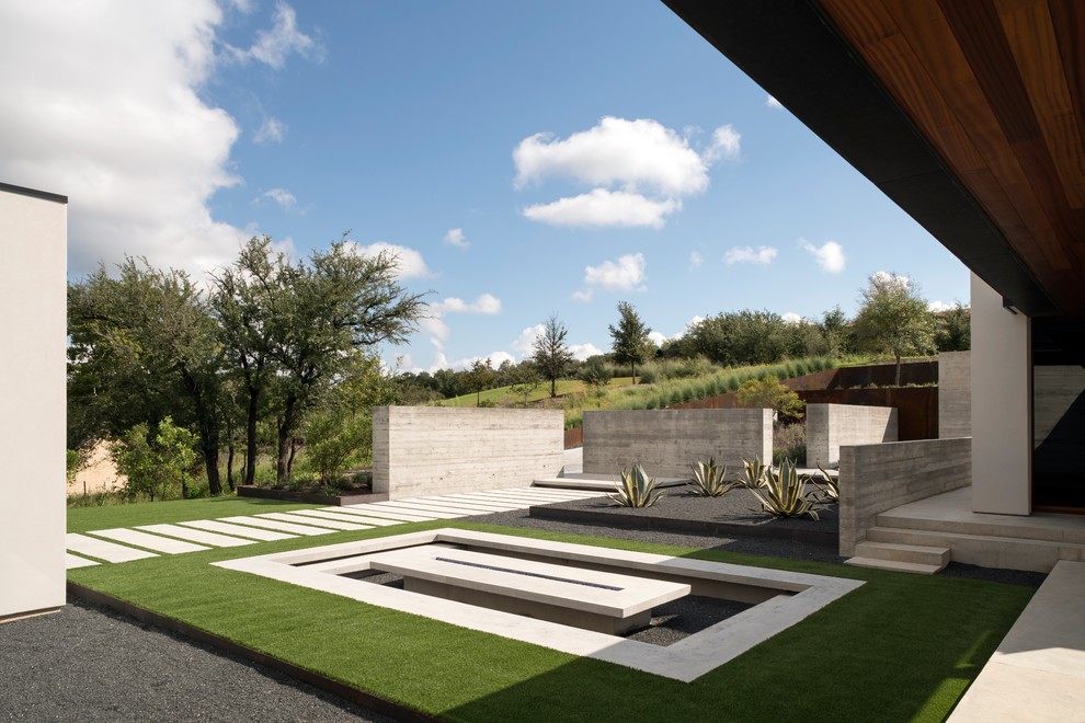 Aménagement d'un jardin moderne avec un foyer extérieur et une exposition partiellement ombragée.