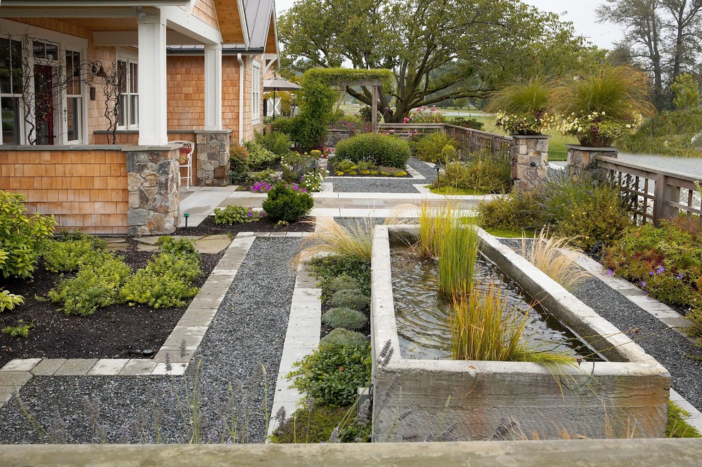 Inspiration for a large traditional full sun front yard concrete paver water fountain landscape in Seattle for summer.