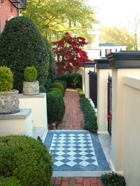 Пример оригинального дизайна: большой солнечный, весенний регулярный сад на переднем дворе в стиле неоклассика (современная классика) с садовой дорожкой или калиткой, хорошей освещенностью и покрытием из каменной брусчатки