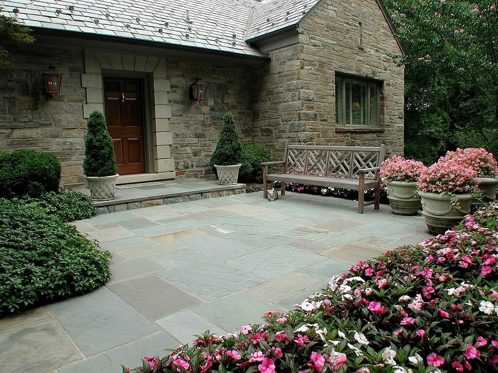 Immagine di un ampio giardino chic esposto a mezz'ombra davanti casa in estate con un giardino in vaso e pavimentazioni in pietra naturale