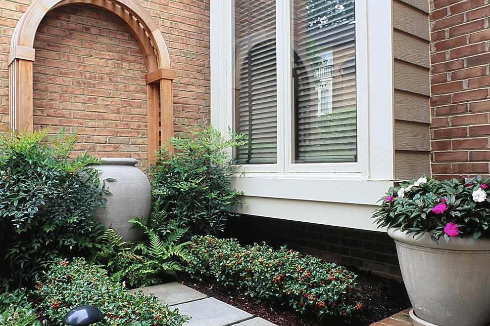 Photo of a small classic front partial sun garden for summer in DC Metro with a garden path and natural stone paving.