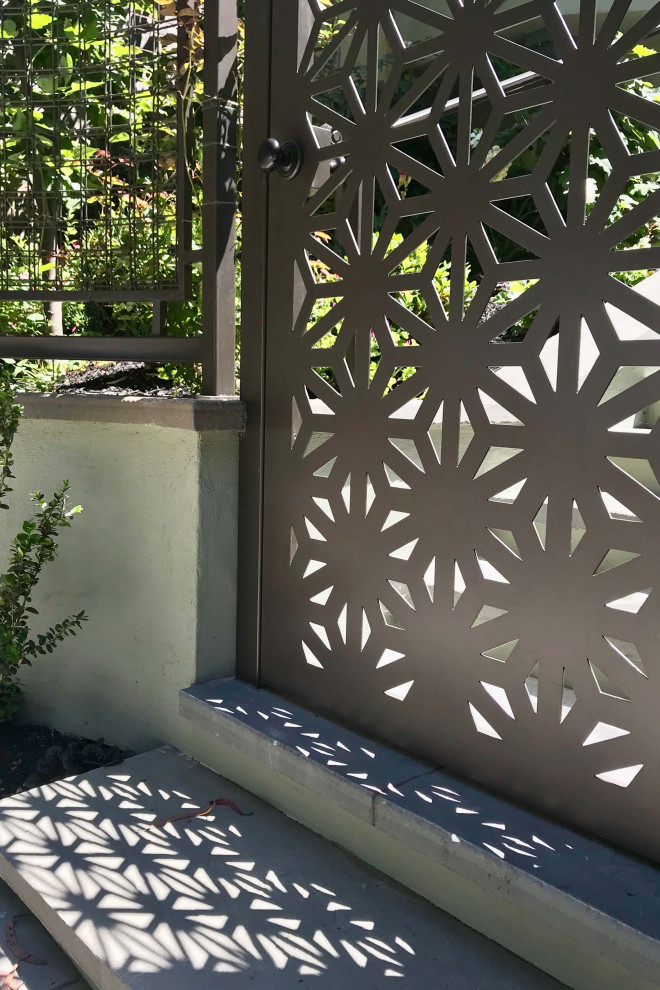 Immagine di un piccolo giardino eclettico esposto a mezz'ombra davanti casa in primavera con cancello e pavimentazioni in pietra naturale