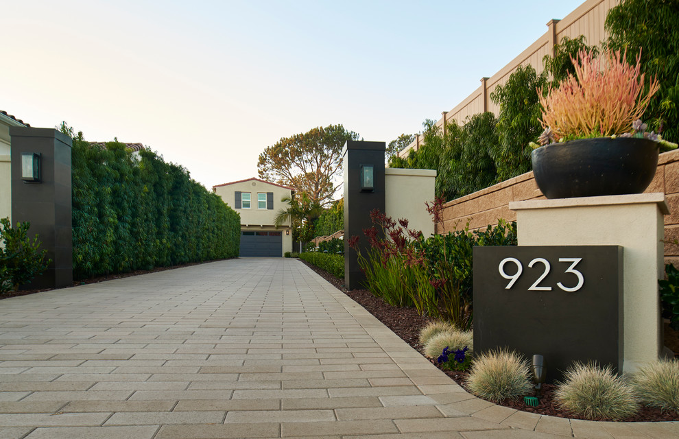 Großer Moderner Vorgarten mit Auffahrt, Kübelpflanzen und Pflastersteinen in San Diego