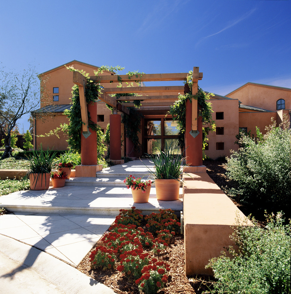 Foto di un grande giardino formale mediterraneo esposto a mezz'ombra davanti casa in estate con un ingresso o sentiero e pavimentazioni in cemento