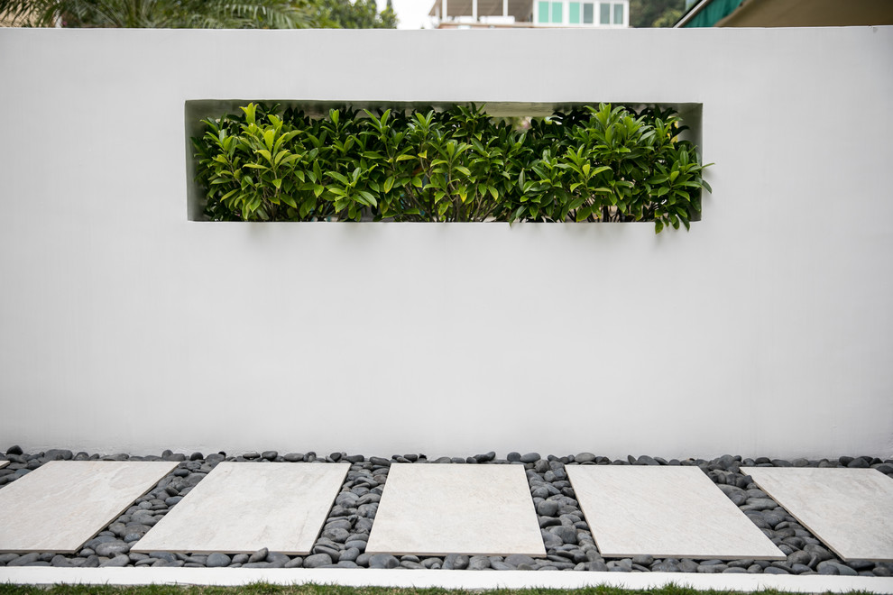 Photo of a mid-sized contemporary front yard concrete paver garden path in Hong Kong.