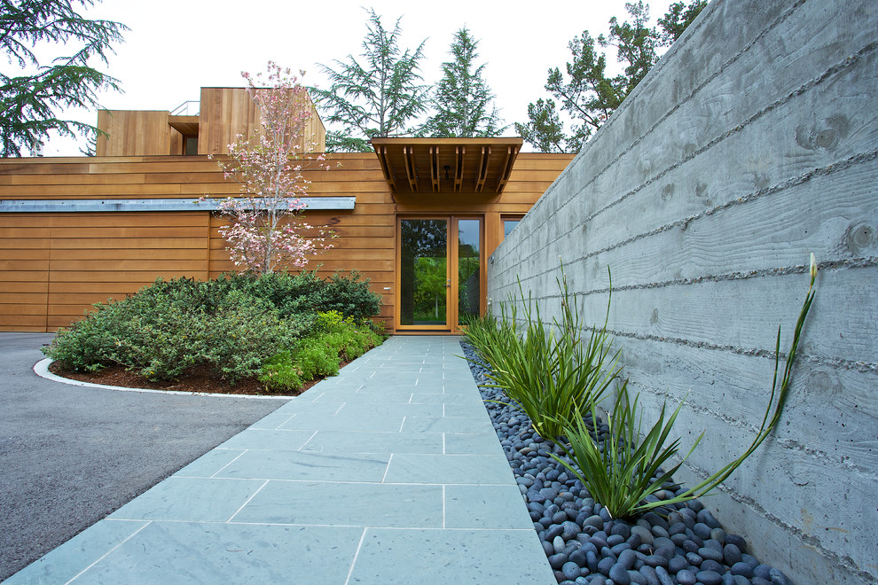 Cette image montre un grand aménagement d'entrée ou allée de jardin avant design avec des pavés en pierre naturelle.