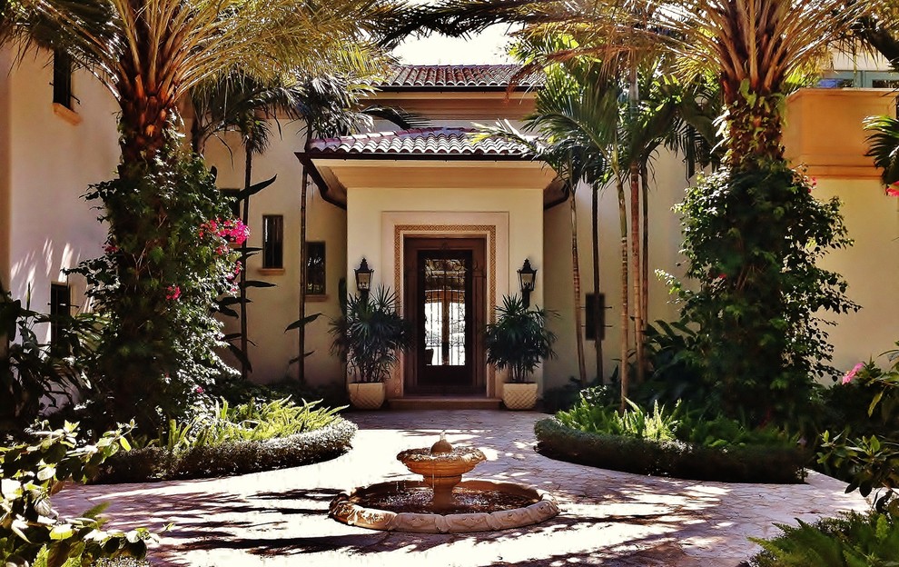 Design ideas for a mediterranean shade front yard water fountain landscape in Miami.