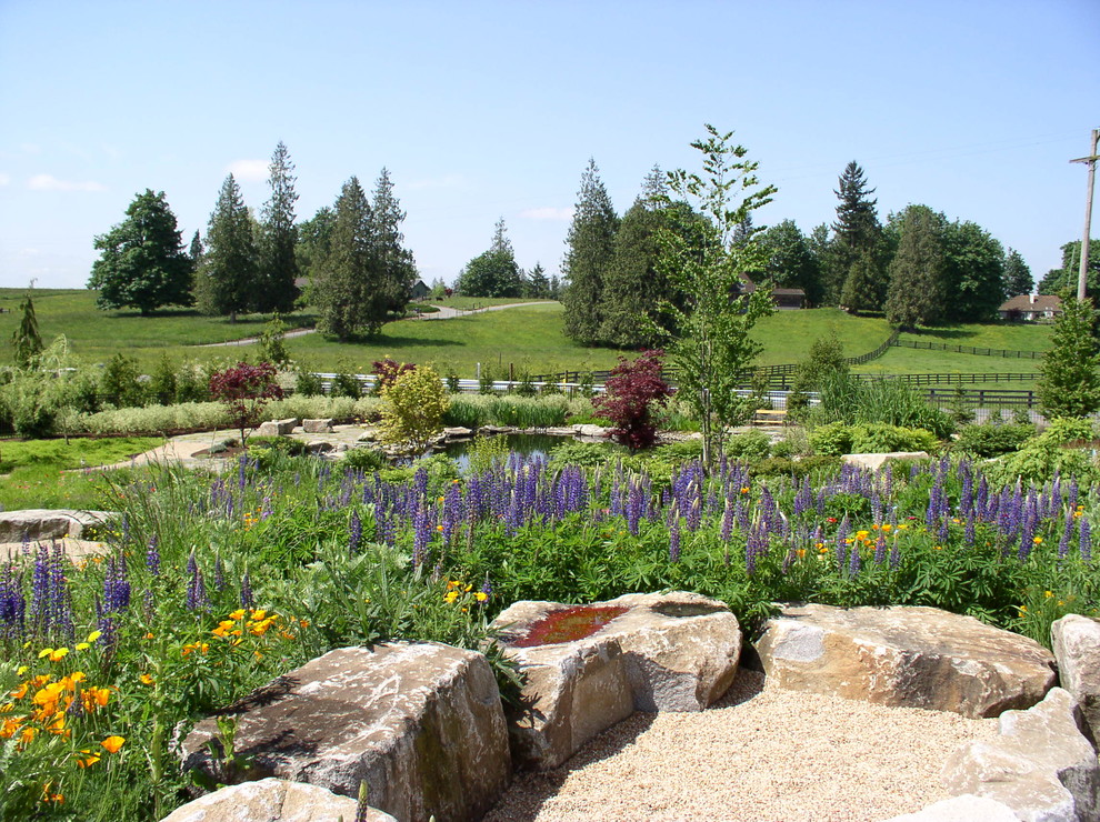 Idee per un ampio giardino country esposto in pieno sole dietro casa con un focolare