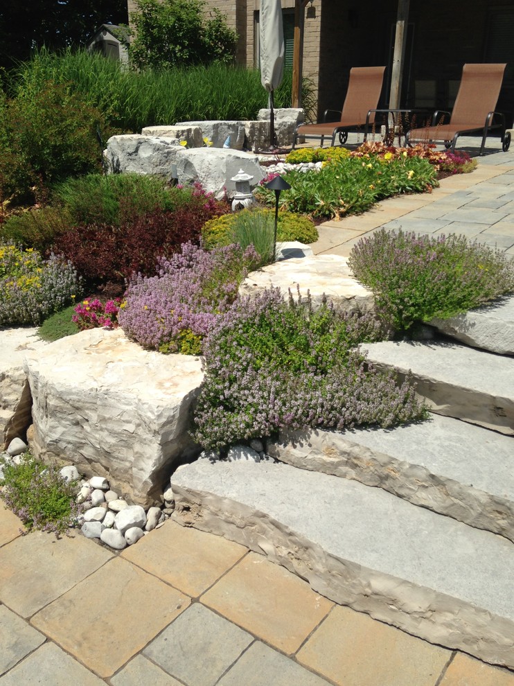 Идея дизайна: весенний регулярный сад среднего размера на заднем дворе в классическом стиле с полуденной тенью и покрытием из каменной брусчатки