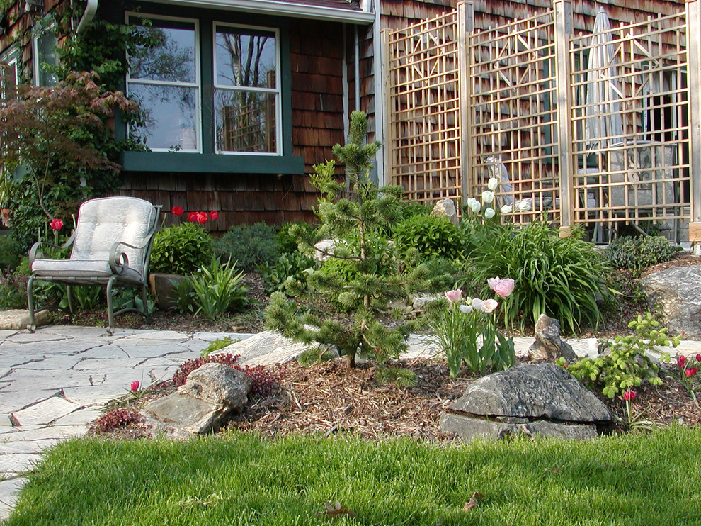 Foto di un giardino tradizionale in primavera con pavimentazioni in pietra naturale