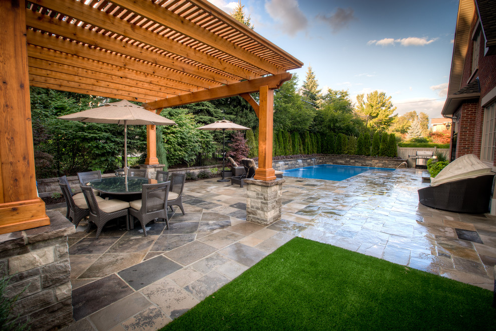 Photo of a large contemporary partial sun backyard stone water fountain landscape in Toronto for summer.