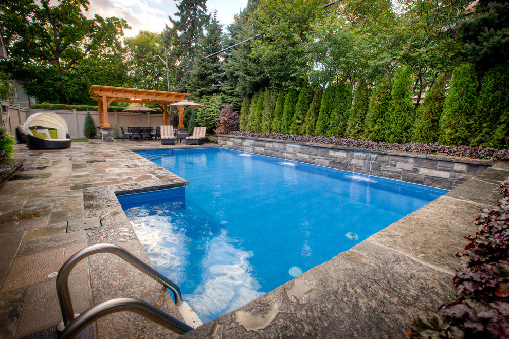 Стильный дизайн: большой бассейн на заднем дворе в современном стиле с покрытием из каменной брусчатки - последний тренд