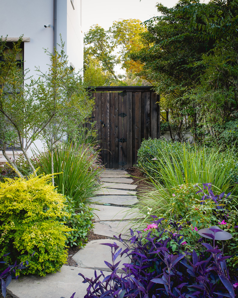 Immagine di un giardino tradizionale esposto a mezz'ombra di medie dimensioni e davanti casa in estate con pavimentazioni in pietra naturale