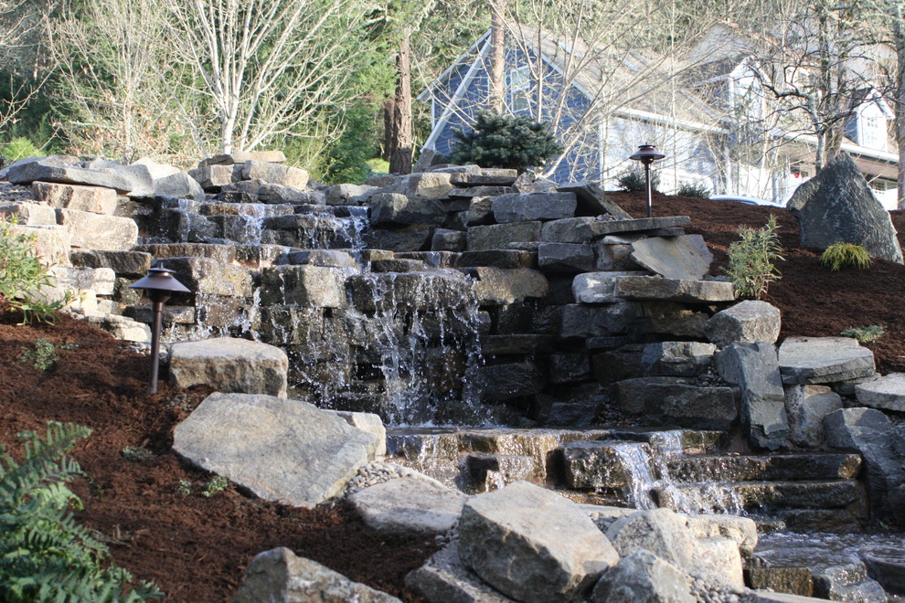 This is an example of a large traditional hillside mulch landscaping in Other for winter.