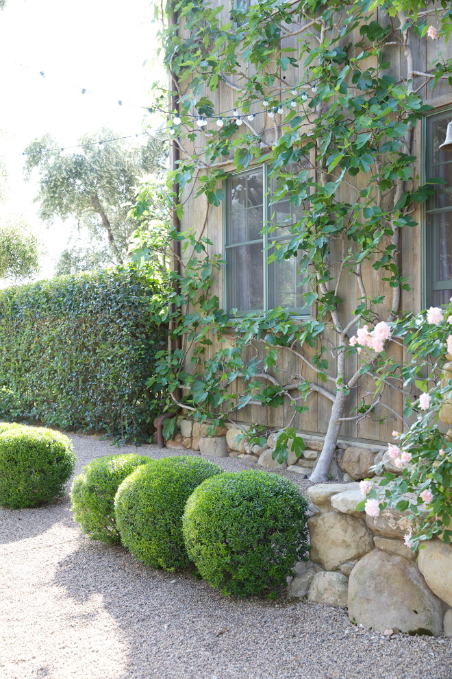 На фото: участок и сад в средиземноморском стиле с полуденной тенью и покрытием из гравия с