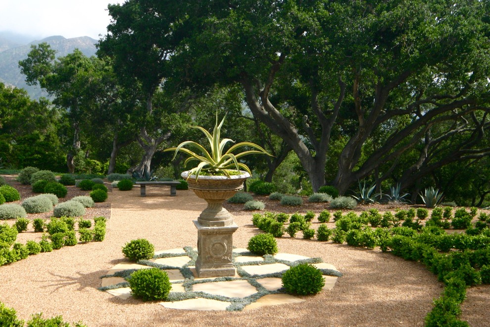 Photo of a mediterranean back formal garden in Other with gravel.
