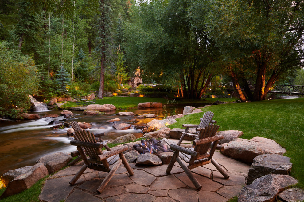 Imagen de jardín rústico extra grande en verano en patio trasero con brasero, adoquines de piedra natural y exposición total al sol
