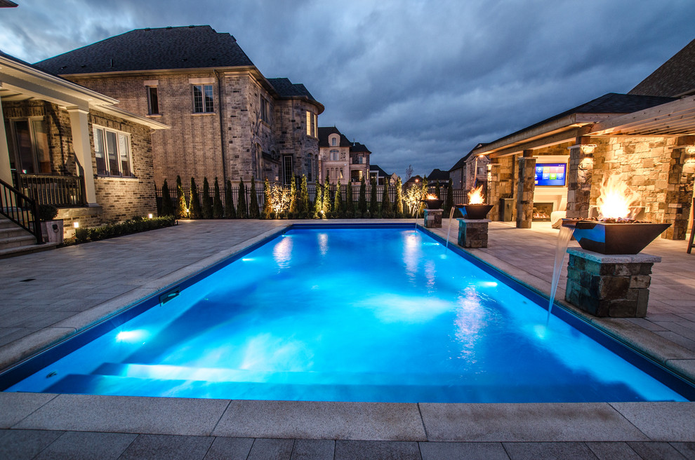 На фото: бассейн среднего размера на заднем дворе в средиземноморском стиле с мощением тротуарной плиткой
