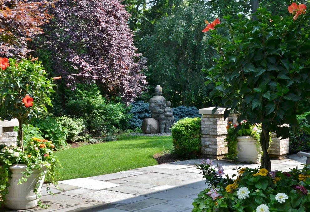 Cette image montre un jardin à la française arrière ethnique de taille moyenne et l'été avec une exposition partiellement ombragée et des pavés en béton.