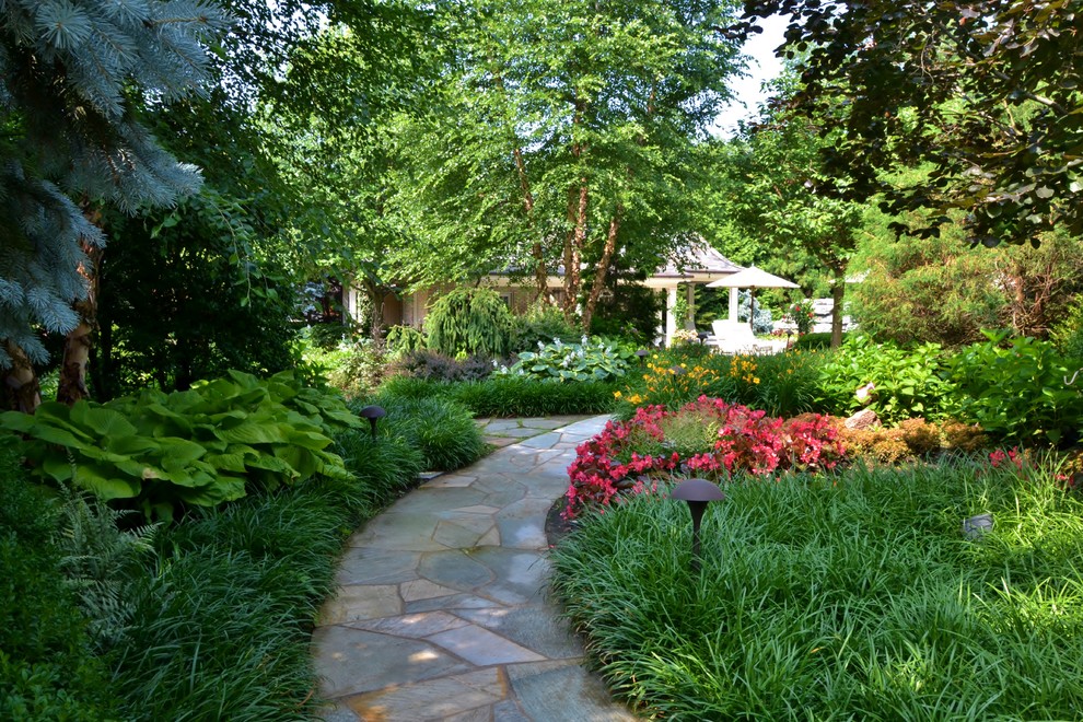 Inspiration for a mid-sized tropical partial sun side yard concrete paver garden path in New York for summer.