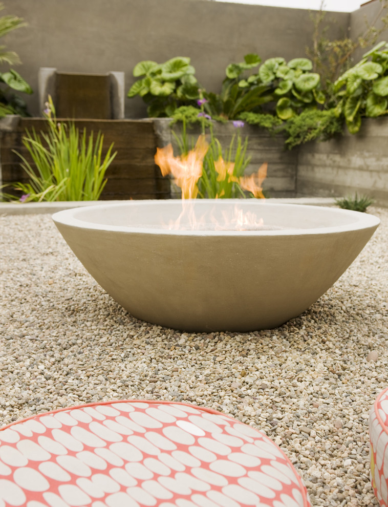 Design ideas for a mid-century modern courtyard landscaping in Orange County with a fire pit.